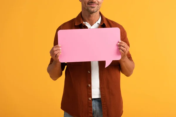 Cropped view of happy man holding pink speech bubble isolated on orange — Stock Photo