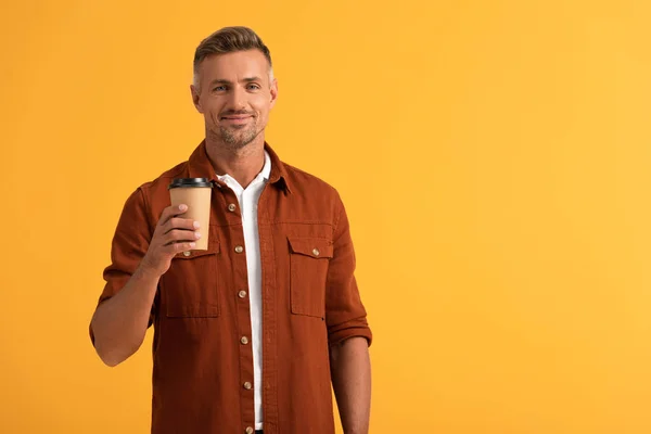 Hombre feliz sosteniendo taza de papel aislado en naranja - foto de stock