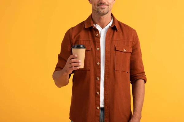 Vista recortada del hombre sosteniendo taza de papel aislado en naranja - foto de stock