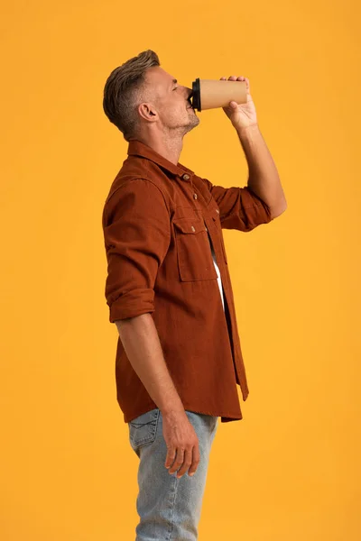 Schöner Mann, der Kaffee trinkt, um allein auf Orange zu gehen — Stockfoto