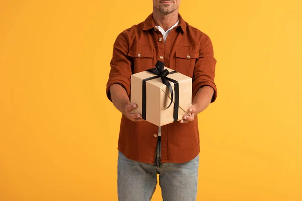 Cropped view of happy man holding present isolated on orange — Stock Photo