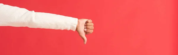 Panoramic shot of man showing thumb down isolated on red — Stock Photo