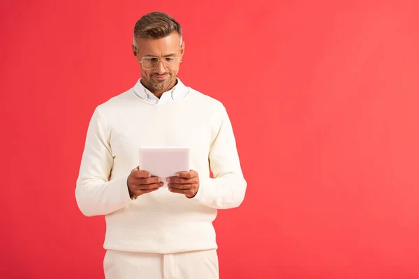 Homme heureux utilisant tablette numérique isolé sur rouge — Photo de stock