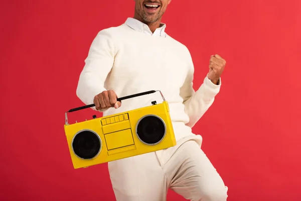 Cropped view of happy man holding retro boombox isolated on red — Stock Photo