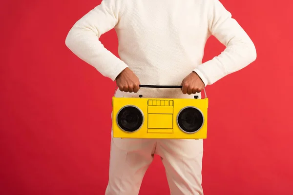 Cropped view of man holding retro boombox isolated on red — Stock Photo