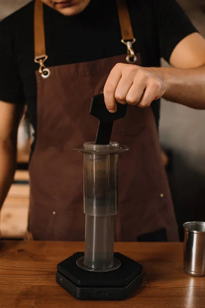 Vista recortada de barista preparando café con aeroprensa - foto de stock
