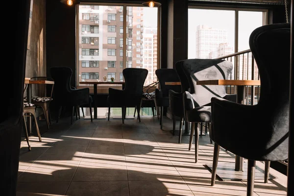 Balcón con mesas y sillas en la moderna cafetería loft a la luz del sol - foto de stock