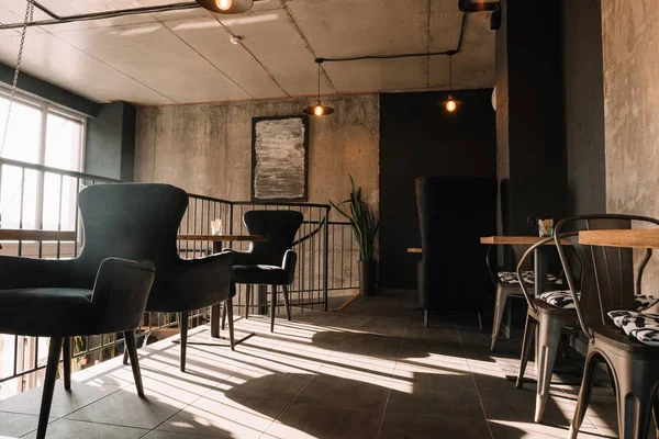 Balkon mit Tischen und Stühlen in modernem Loft-Kaffeehaus im Sonnenschein — Stockfoto