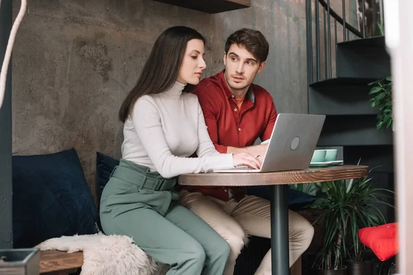 Молода пара працює разом на ноутбуці в кав 