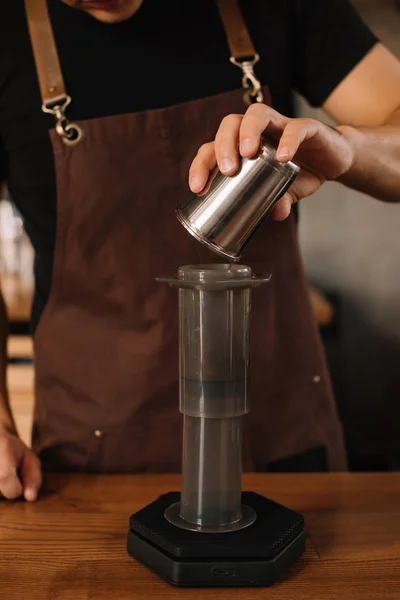 Vista recortada de barista preparando café elaborado con aeroprensa - foto de stock