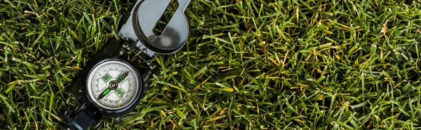 Panoramic shot of retro compass on green grass — Stock Photo