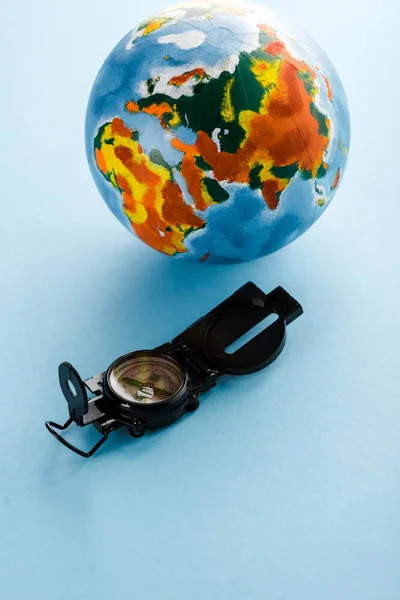 Retro-Kompass nahe bunter Erdkugel auf blauem Grund — Stockfoto