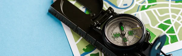 Panoramic shot of retro and black compass on map on blue — Stock Photo