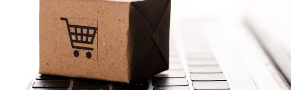 Plano panorámico de caja de cartón de juguete en teclado portátil aislado en blanco, concepto de comercio electrónico - foto de stock