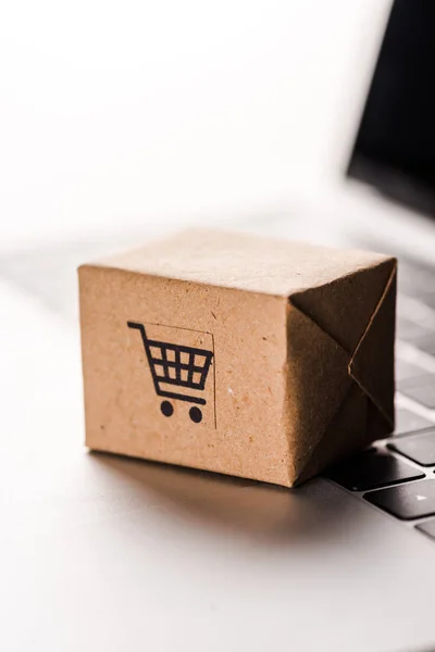 Primer plano de la caja de juguetes en el teclado del ordenador portátil aislado en blanco, concepto de comercio electrónico - foto de stock