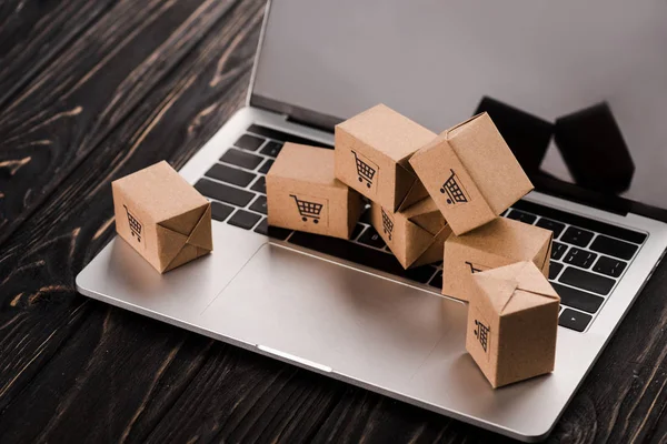 Piccole scatole di cartone su laptop con schermo bianco, concetto di e-commerce — Foto stock