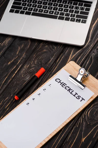 Laptop perto de checklist e caneta marcador vermelho na mesa, conceito de e-commerce — Fotografia de Stock