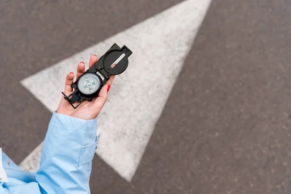 Ausgeschnittene Ansicht einer Frau mit Oldtimer-Kompass in der Nähe der Straße — Stockfoto