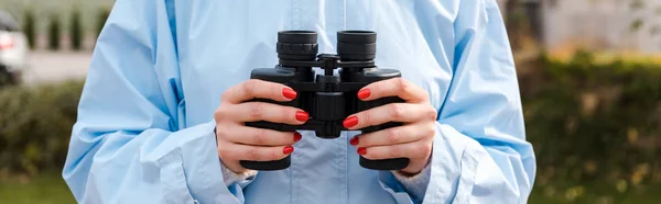Tiro panorâmico de mulher segurando binóculos — Fotografia de Stock
