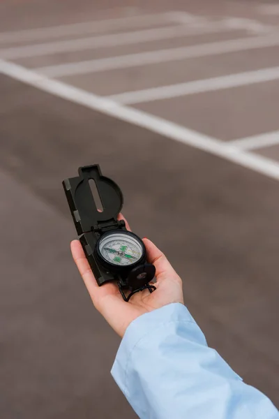 Cropped view of woman holding compass near road — Stock Photo