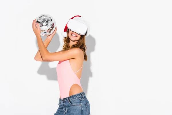 Mulher alegre em santa chapéu segurando segurando bola de discoteca no branco — Fotografia de Stock