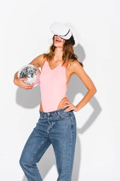 Веселая девушка в шляпе Санты держит диско мяч на белом — стоковое фото