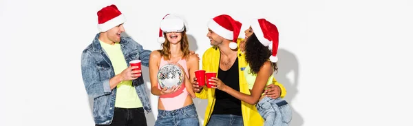 Plan panoramique d'amis multiculturels heureux près femme gaie en réalité virtuelle casque avec boule disco sur blanc — Photo de stock