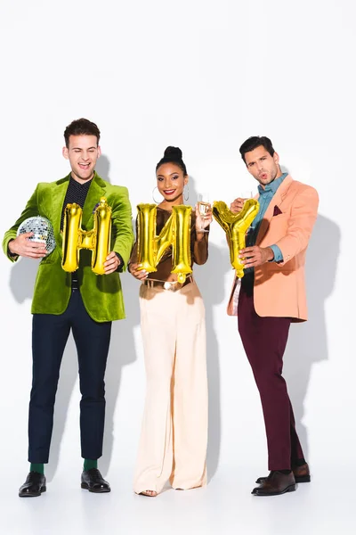 Happy african american girl near men and balloons on white — Stock Photo