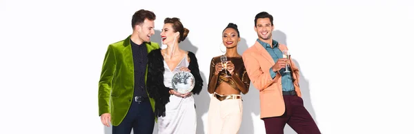 Panoramaaufnahme glücklicher und stilvoller multikultureller Freunde mit Champagnergläsern und Discokugel auf weißem Grund — Stockfoto