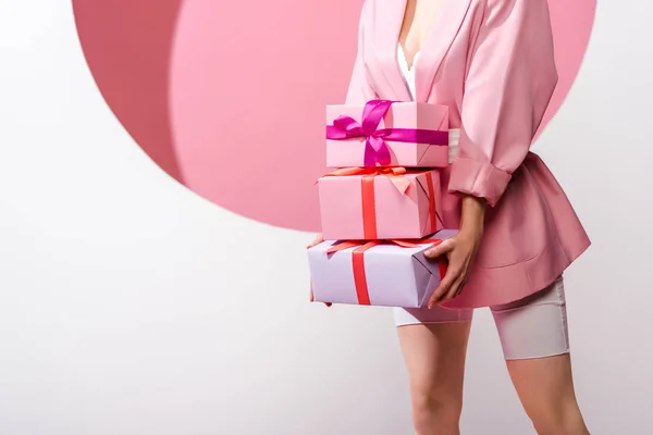 Vue recadrée de femme tenant des cadeaux sur blanc et rose — Photo de stock