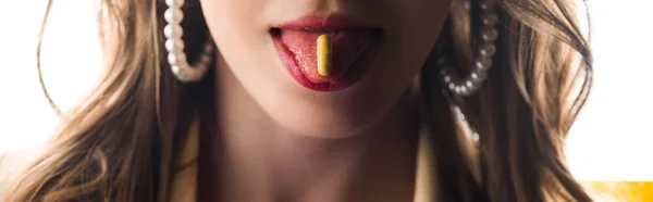 Panoramic shot of woman sticking out tongue with yellow pill on white — Stock Photo