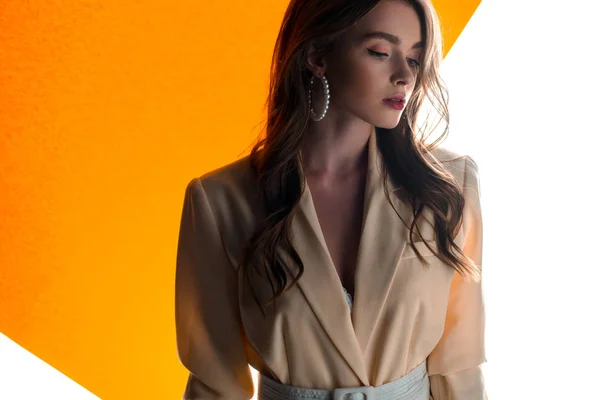 Jeune femme attrayante debout sur orange et blanc — Photo de stock