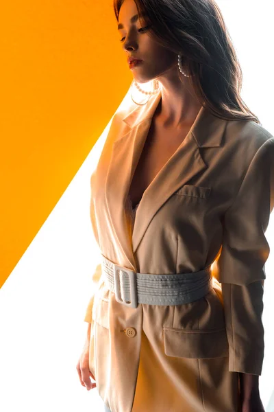 Jolie jeune femme en blazer sur orange et blanc — Photo de stock