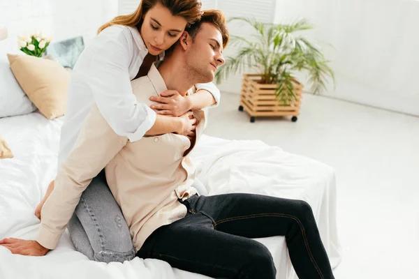 Attractive girlfriend with closed eyes hugging handsome boyfriend in apartment — Stock Photo