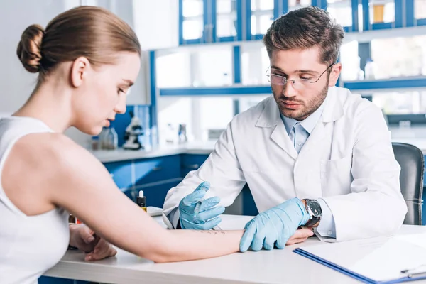 Selective focus of allergist holding syringe near woman in clinic — Stock Photo