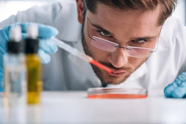 Foco seletivo do imunologista segurando pipeta com líquido vermelho — Fotografia de Stock