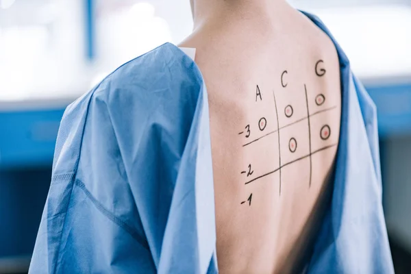 Vista recortada de la mujer con números y letras en la espalda marcada - foto de stock