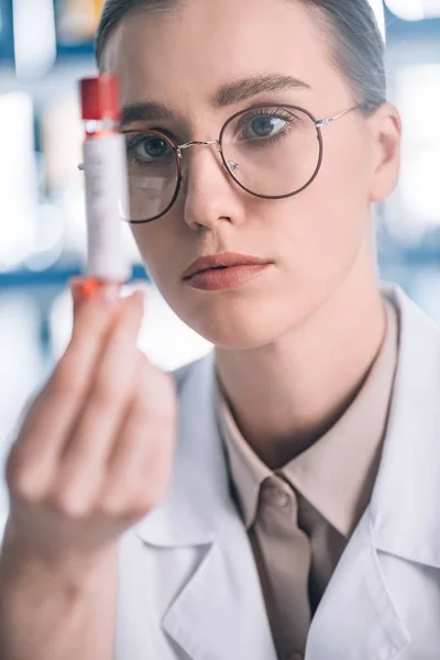 Selective focus of attractive allergist in glasses holding test tube — Stock Photo