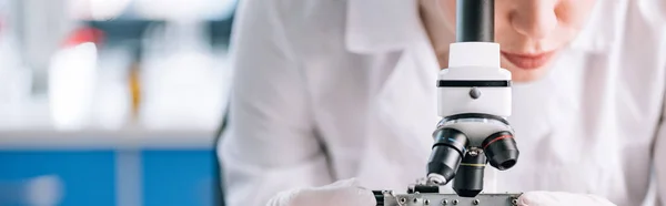 Panoramaaufnahme eines Immunologen, der im Labor durch das Mikroskop schaut — Stockfoto