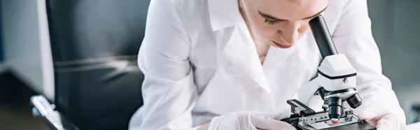 Plan panoramique de la femme regardant à travers le microscope — Photo de stock