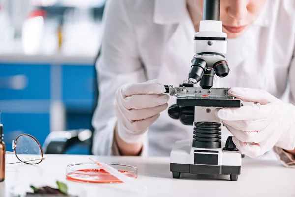 Vista recortada del inmunólogo mirando a través del microscopio - foto de stock