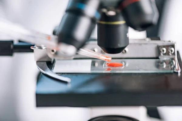 Selective focus of red sample in microscope — Stock Photo