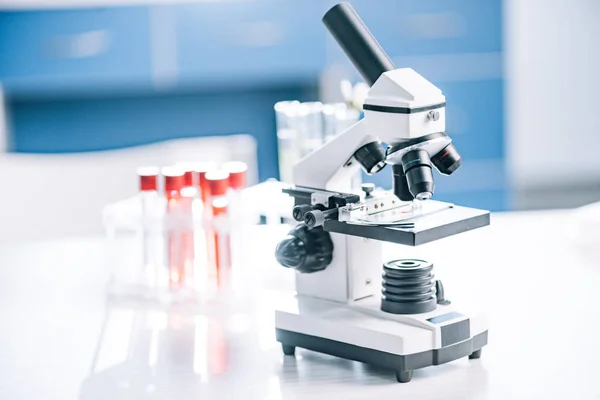 Selective focus of modern microscope near test tubes with samples — Stock Photo