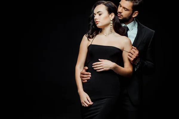 Красивий чоловік роздягається дівчина в одязі ізольована на чорному — стокове фото