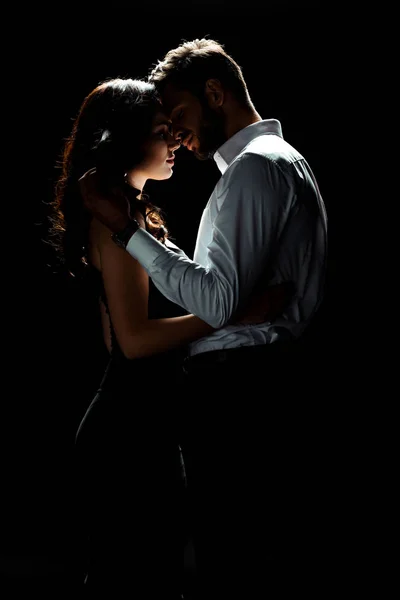 Side view of happy man touching woman while standing isolated on black — Stock Photo