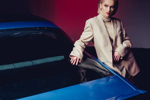 Attraktive und stilvolle Frau im Anzug berührt Retro-Auto — Stockfoto
