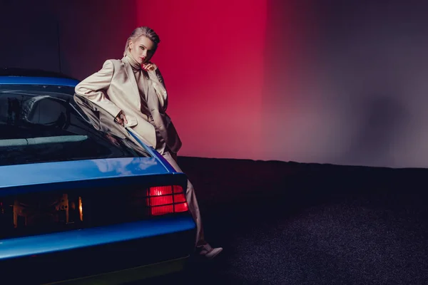 Mujer atractiva y elegante en traje de pie cerca de coche retro - foto de stock