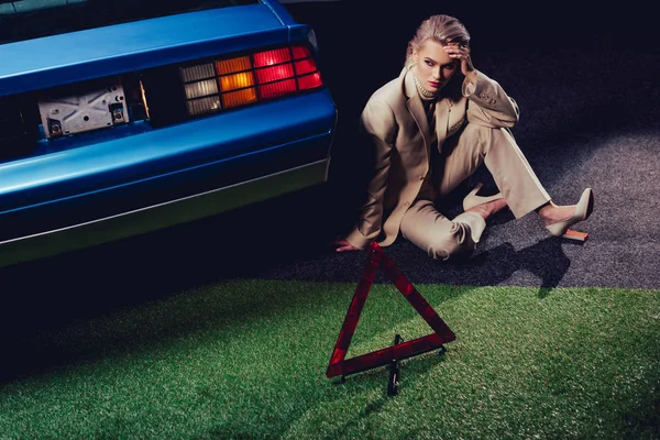 Attractive and stylish woman in suit sitting near retro car — Stock Photo