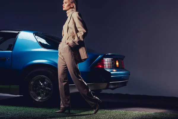 Mulher atraente e elegante em terno andando perto de carro retro — Fotografia de Stock