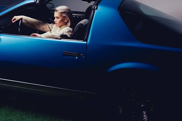 Високий кут зору привабливої і стильної жінки в костюмі сидячи в ретро автомобілі — Stock Photo